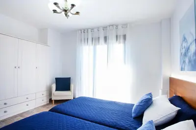 a bedroom with a blue bed and a chair at Casa rural Torre Buena Vista a 40 minutos de Valencia con gran jacuzzi y vistas maravillosass in Benafer