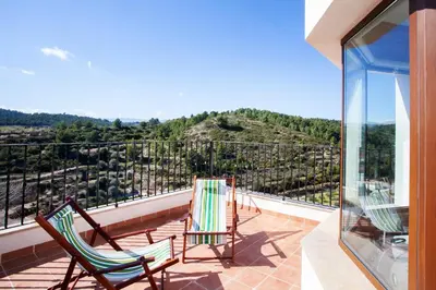 a balcony with two chairs and a view of a mountain at Casa rural Torre Buena Vista a 40 minutos de Valencia con gran jacuzzi y vistas maravillosass in Benafer