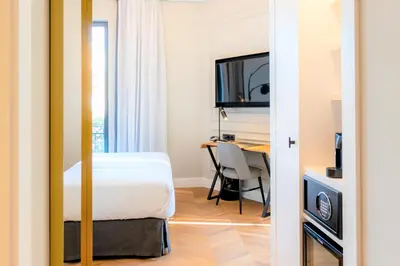 a bedroom with a bed and a desk with a table at L&H Gran Vía Valencia in Valencia