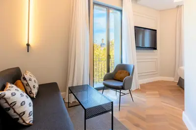 a living room with a couch and a chair and a window at L&H Gran Vía Valencia in Valencia
