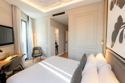 a hotel room with a bed and a desk at L&H Gran Vía Valencia in Valencia