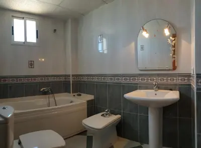 a bathroom with a sink and a tub and a toilet at Vacansis Adosado Marenyet in Cullera