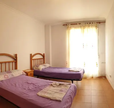 a bedroom with two beds and a window at Vacansis Adosado Marenyet in Cullera