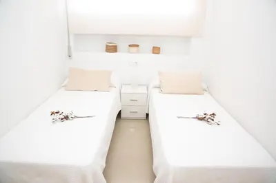 two beds in a small room with white walls at Summer Beach House in Puebla de Farnals