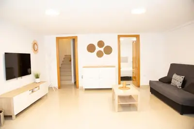 a living room with a couch and a tv at Summer Beach House in Puebla de Farnals