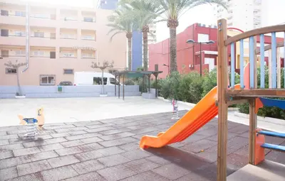 a playground with an orange slide in a park at Summer Beach House in Puebla de Farnals