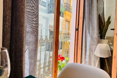 a white chair sitting in front of a window at Acogedor apartamento centro histórico Valencia in Valencia