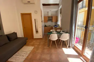a living room with a couch and a table and chairs at Acogedor apartamento centro histórico Valencia in Valencia