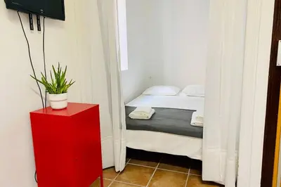 a bedroom with a bed and a red cabinet with a potted plant at Acogedor loft en centro histórico in Valencia