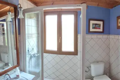 a bathroom with a shower and a toilet and a window at La Casa de Piedra, una ventana al paraíso in Matet