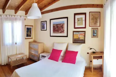 a bedroom with a white bed with two red pillows at La Casa de Piedra, una ventana al paraíso in Matet