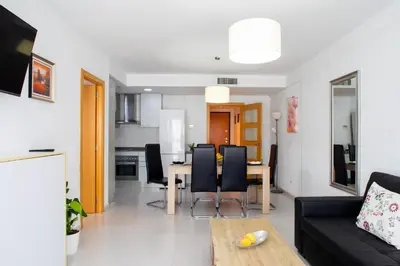 a living room with a black couch and a table at FLORIT FLATS - The Malvarrosa Beach Apartment & Free Parking in Valencia