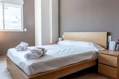 a bedroom with a bed with towels on it at Global Vacacional, Apartamento a 200m de la playa de Puerto de Sagunto in Puerto de Sagunto