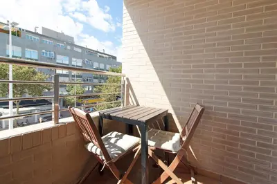 a table and two chairs sitting on a balcony at Global Vacacional, Apartamento a 200m de la playa de Puerto de Sagunto in Puerto de Sagunto