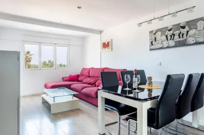 a living room with a red couch and a table at Fantástico Apartamento en Primerísima Línea Playa in La Torre
