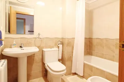 a bathroom with a toilet and a sink and a tub at Global Vacacional, Ático con 2 terrazas en la playa Puerto de Sagunto in Puerto de Sagunto