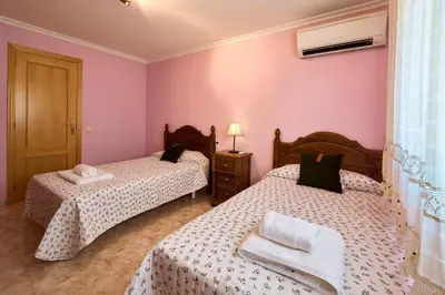 two beds in a room with pink walls at Casa Rural 