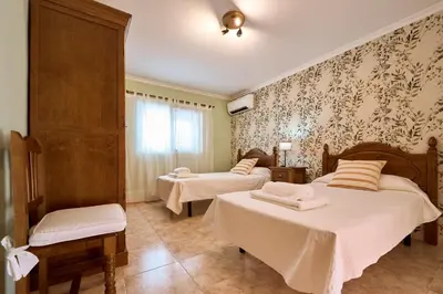 a room with two beds in a room with wallpaper at Casa Rural 