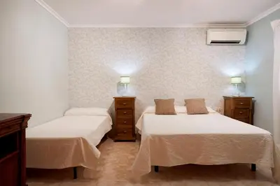 a bedroom with two beds and two lights on the wall at Casa Rural 