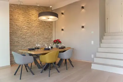 a dining room with a table and chairs and a brick wall at Colina del Sol Cullera - Villa Luna in Cullera