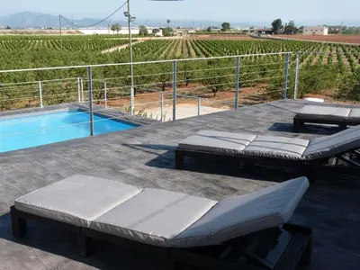 a patio with two beds and a swimming pool at Huerto del Medico in Reig