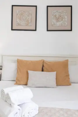 a white couch with pillows and two pictures on the wall at Travel Habitat - Ático Centro in Valencia