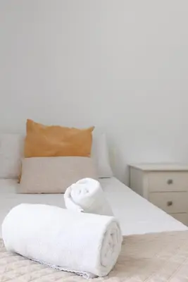 a white bed with two towels on it at Travel Habitat - Ático Centro in Valencia
