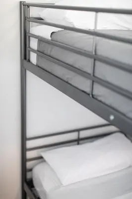 a row of bunk beds with white pillows at BUBUFLATS / Mercat in Valencia