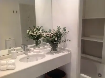 a bathroom with a sink with flowers in a mirror at Apartamento Reina Catedral in Valencia