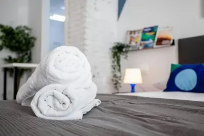 a rolled up towel sitting on top of a bed at COOL LOFTS center valencia in Valencia