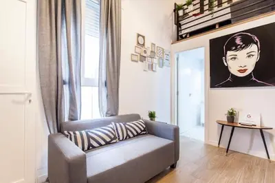 a living room with a couch and a picture of a woman at COOL LOFTS center valencia in Valencia