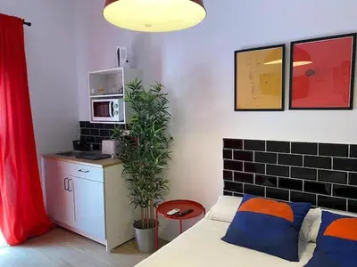 a room with a bed and a kitchen with a microwave at COOL LOFTS center valencia in Valencia