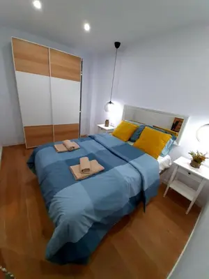 a large blue bed in a bedroom with yellow pillows at UIM Mediterraneo PB Columbretes 12 Wifi in Puerto de Sagunto