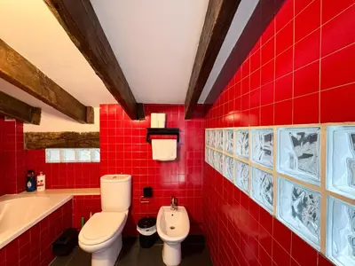 a red bathroom with a toilet and a sink at Duplex al lado de los Jardines del Turia in Valencia