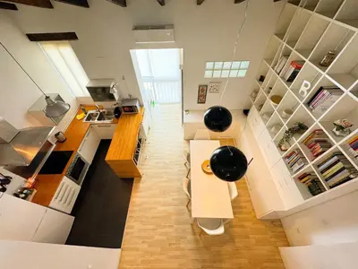 a kitchen with white cabinets and a table in a room at Duplex al lado de los Jardines del Turia in Valencia