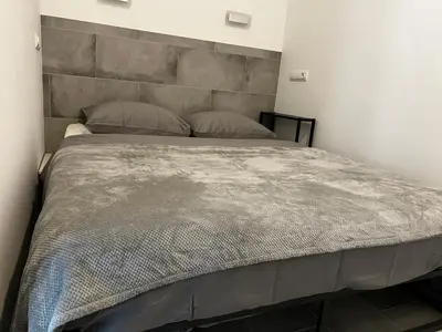 a bedroom with a large bed with a concrete headboard at Apartment near the port, City Of Arts and 10min to the beach in Valencia
