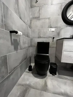 a bathroom with a black toilet and a sink at Apartment near the port, City Of Arts and 10min to the beach in Valencia