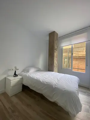 a white bedroom with a bed and a window at Cozy flat in La Petxina_A in Valencia