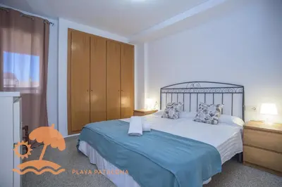 a bedroom with a large bed with a blue blanket at Patacona Green Holiday in Valencia