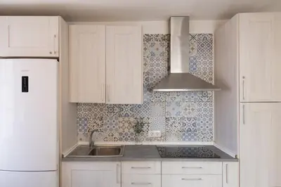 a kitchen with white cabinets and a sink and a refrigerator at Benlloch Silence in Valencia