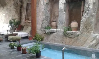 a swimming pool in a stone building with potted plants at CASA PORTALICO in Jérica