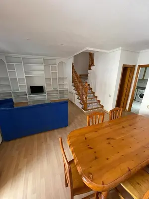 a dining room with a table and chairs and a staircase at Precioso adosado con parking a 100 metros de la playa in Playa de Mar