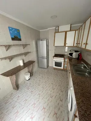 a kitchen with a refrigerator and a sink at Precioso adosado con parking a 100 metros de la playa in Playa de Mar