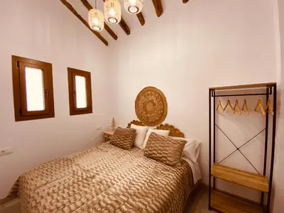 a bedroom with a bed and a chandelier at Apartamentos Casa Anselmo EL TERRAO in Losa del Obispo