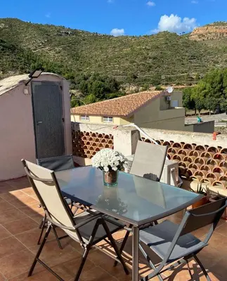 a table and chairs on a patio with a view at Apartamentos Casa Anselmo EL TERRAO in Losa del Obispo