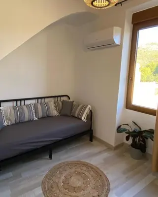 a couch in a room with a window and a rug at Apartamentos Casa Anselmo EL TERRAO in Losa del Obispo