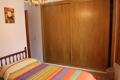 a bedroom with a large wooden closet and a bed at Casa Arminda in Benafer