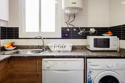 a kitchen with a sink and a dishwasher and a microwave at Apartamentos FV Flats Valencia - Mestalla 7 in Valencia