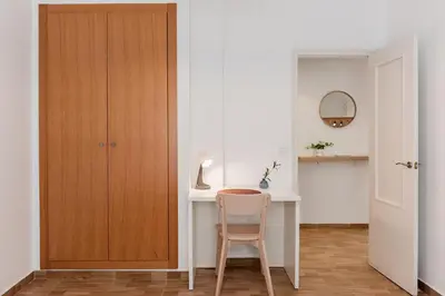a room with a desk with a chair and a cabinet at Apartamentos FV Flats Valencia - Mestalla 7 in Valencia