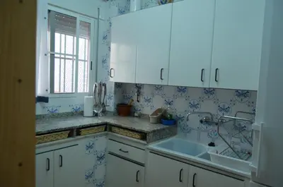 a kitchen with white cabinets and blue wallpaper at Casa el Castell in Eslida